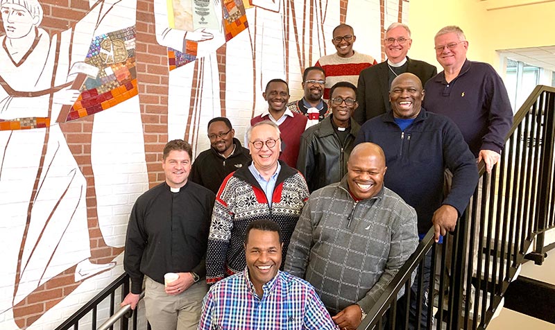 LLDP participants in the November 2019 classes pose with LLDP instructors. [Left-most row, l-r diagonally ascending the stairs: Deputy Bishop Helmut Paul (FELSISA); District Pastor Daniel Mono (ELCT-SELVD); Bishop Emmanuel Makala (ELCT-SELVD); General Secretary Teshome Amenue (EECMY); Tsegahun Assefa, Director of Children and Youth (EECMY). Middle row, l-r diagonally ascending the stairs: Rev. Dr. Naomichi Masaki, LLDP Director; President John Donkoh (ELCG); and Rev. Dr. Timothy Quill, LLDP faculty and General Secretary (ILC); Right-most row, l-r diagonally ascending the stairs: Rev. Dr. Bruk Ayele (EECMY); Deputy Bishop Mandla Thwala (LCSA); Bishop Modise Maragelo (LCSA); and Professor John Pless, LLDP faculty and Assistant Professor (CTSFW).